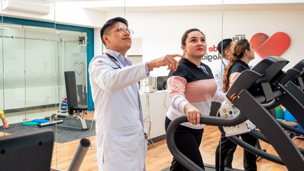 Cardiólogo junto a paciente en sala de rehabilitación